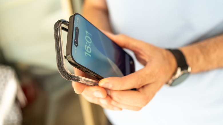 person putting an iphone into a smartphone case