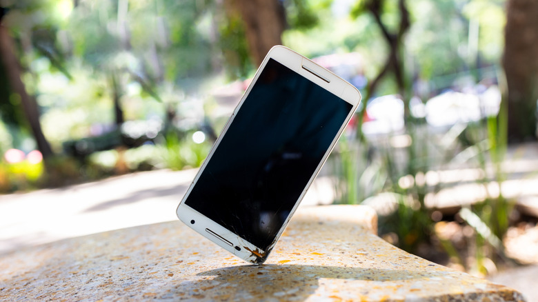 smartphone landing on concrete with cracks showing on device