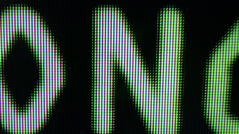 A macro photo of a Mini LED showing slight bloom around letters on a black background.