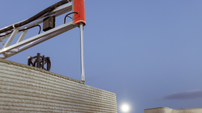 Large-scale 3D printer making a concrete structure on site.