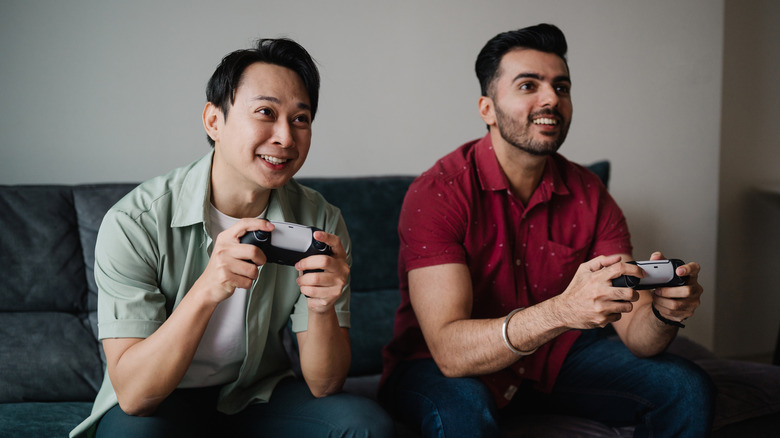 Two men operate gaming controllers