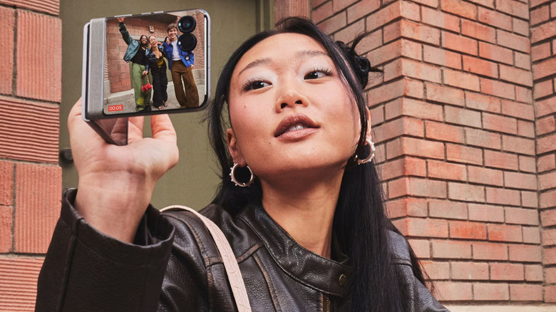 A woman taking a photo with the Motorola Razr 2026