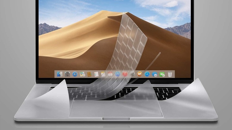 A MacBook with a keyboard protector film half peeled off
