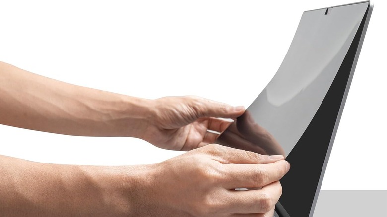 A MacBook screen partially hidden by a privacy screen protector