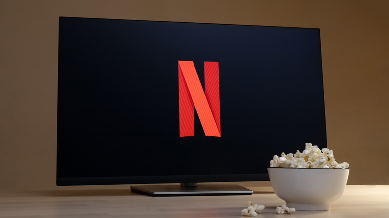 The Netflix logo is pictured on a display, with a popcorn bowl in front.