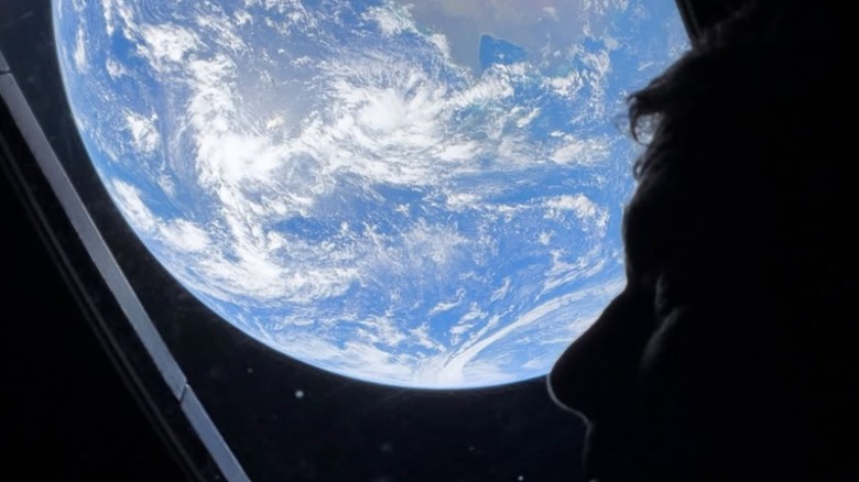 Crew member of the Artemis 2 mission with the Earth on the background