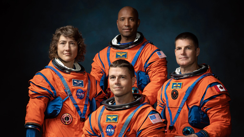 The four astronauts selected for the Artemis II lunar mission pose in their bright orange-and-blue NASA spacesuits.