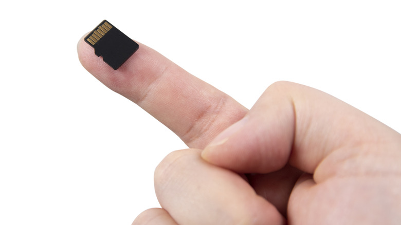 MicroSD card on a finger showing its small size