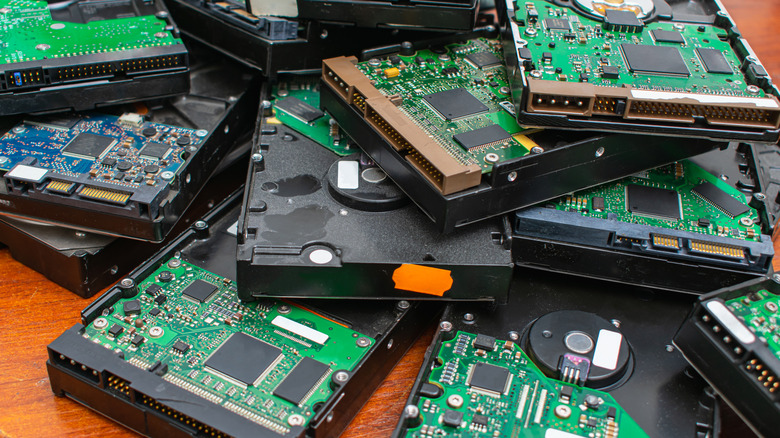 A pile of traditional physical hard drives stacked on a tabletop