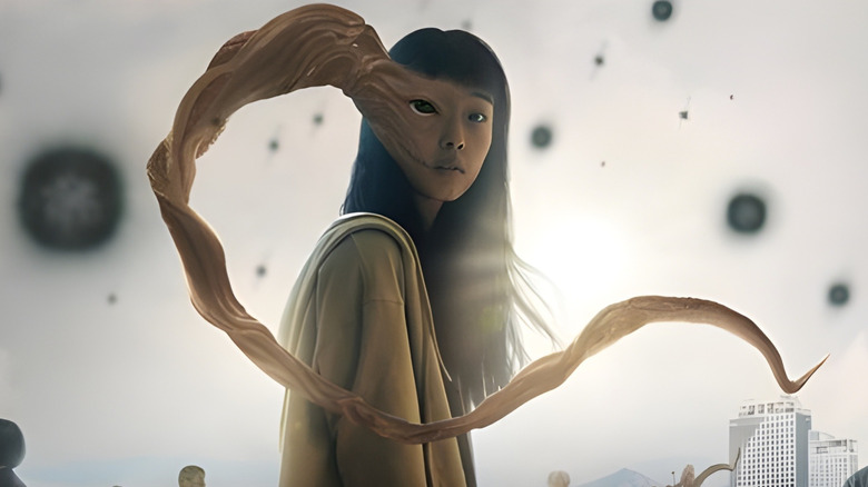 Poster image of Parasyte showing a young woman with a whip-like growth coming out of her face.