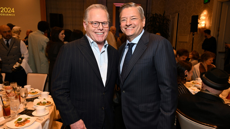 David Zaslav (left) and Ted Sarandos (right), heads of Warner Bros and Netflix, respectively, stand smiling side by side.