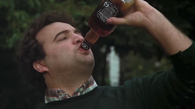 John Belushi as Blutarsky drinking a bottle of whiskey in Animal House
