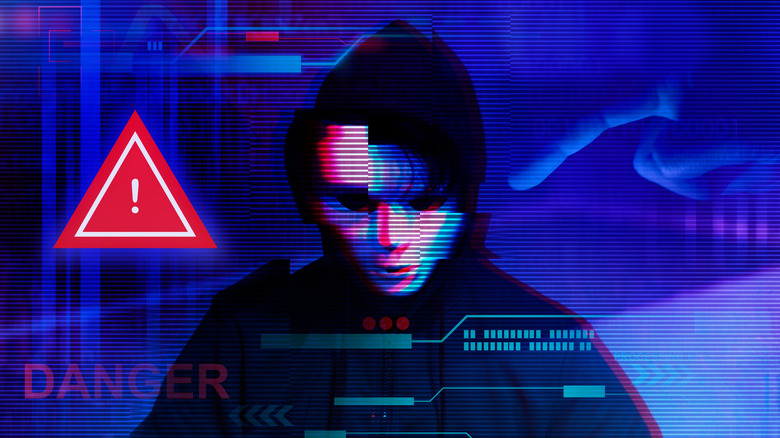 An artists rendering shows a hooded cyberhacker besides a red danger sign.