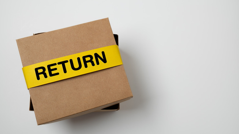 brown cardboard box with a yellow tape titled Return