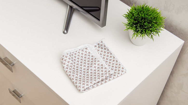 A microfiber cloth next to a TV set and potted plant