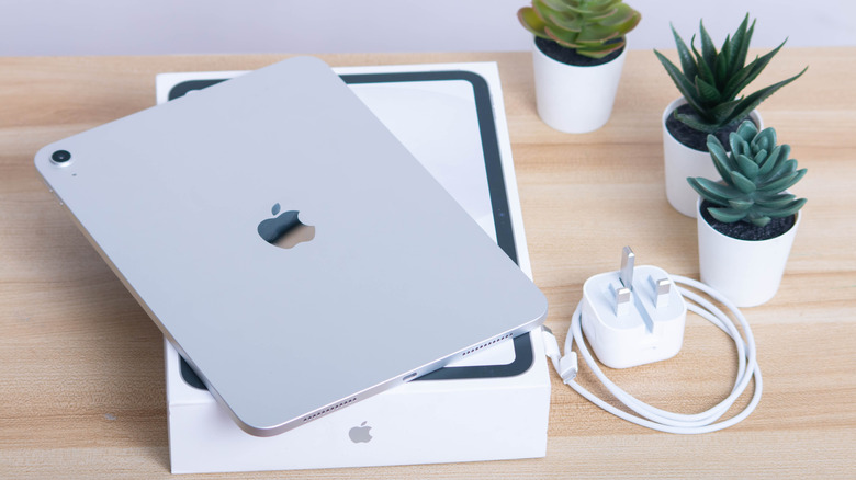The iPad Air 11 with its box and charger on a table.