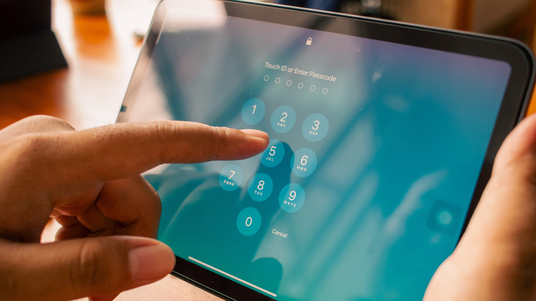 A person typing a passcode to unlock an iPad.