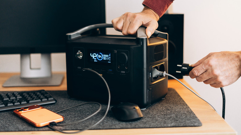 A person hooking up their PC to a UPS