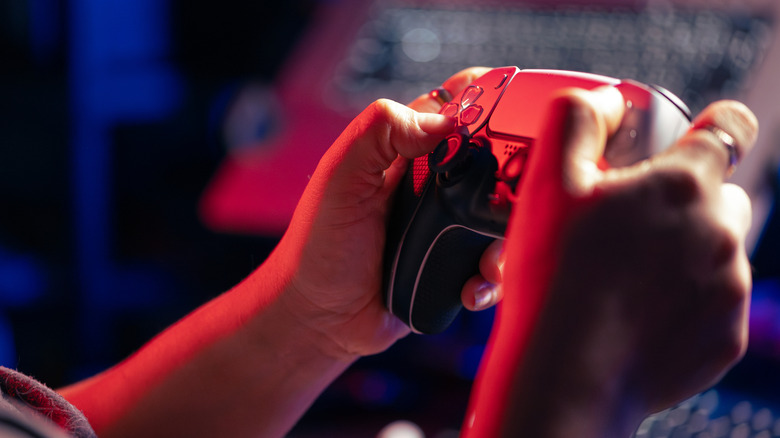 A person holding a DualSense controller in their hands