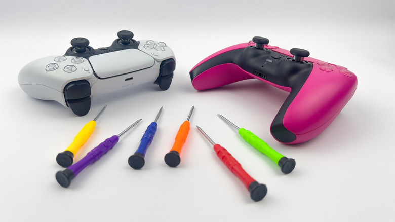 Two DualSense controllers with precision screwdrivers nearby