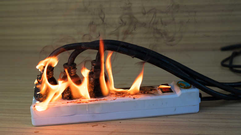 Multiple power cords connected to a power strip on fire
