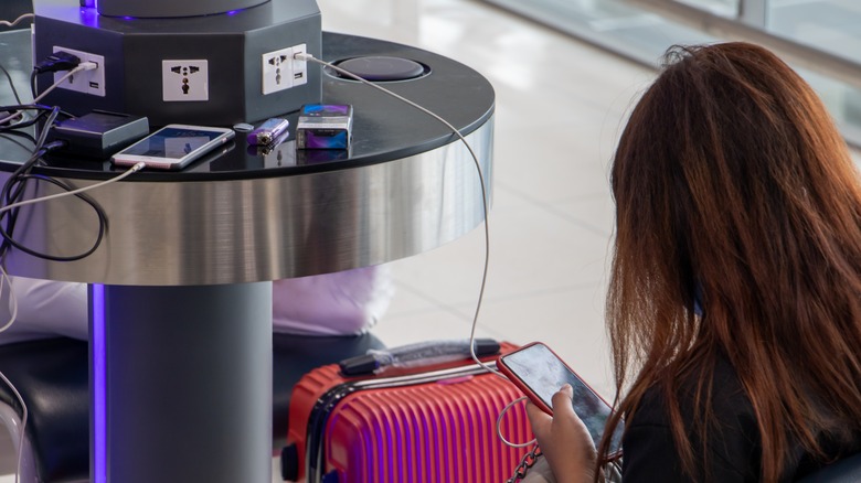 A person charging their phone from a public charging station