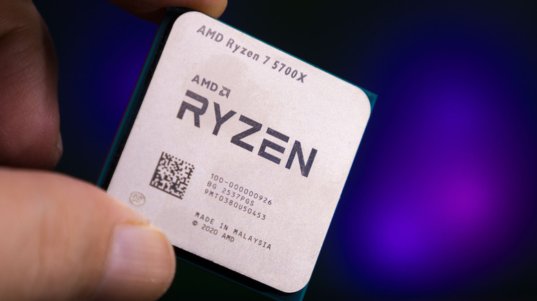 Hand holding an AMD Ryzen processor.