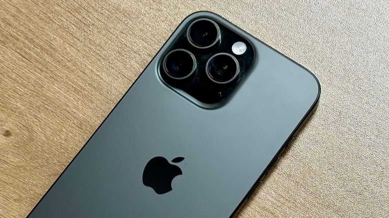 A black iPhone 16 Pro placed face down on a table.