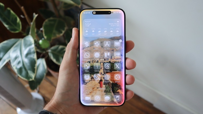 A hand holding an iPhone with the Apple Intelligence UI turned on.