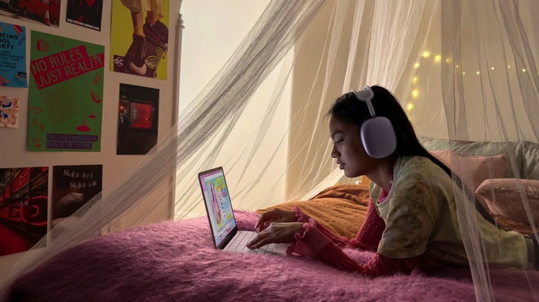 A teenager using a MacBook Neo laptop.