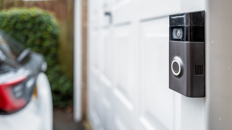 A smart doorbell in front of a garage
