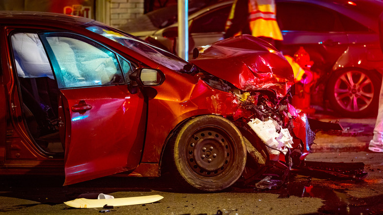 A crashed vehicle on a street at night