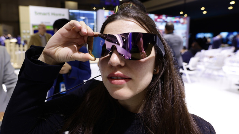 A woman trying on smart glasses at MWC 2023