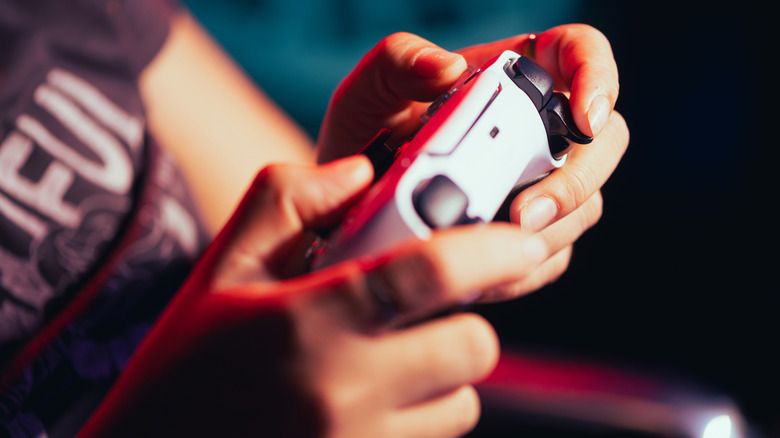 Close-up of hands using PlayStation 5 DualSense controller
