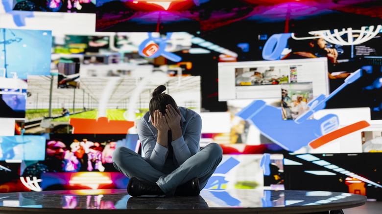 distressed person surrounded by loads of information in the shape of floating windows