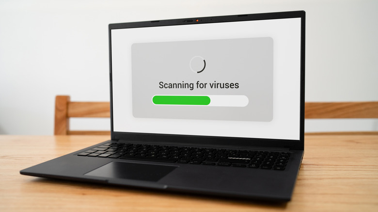 laptop showing a scanning for viruses screen and progress bar on screen