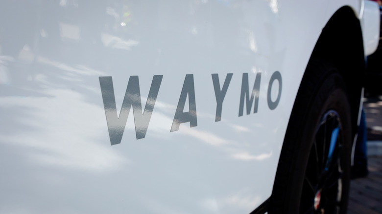 The Waymo logo on the side of a robotaxi