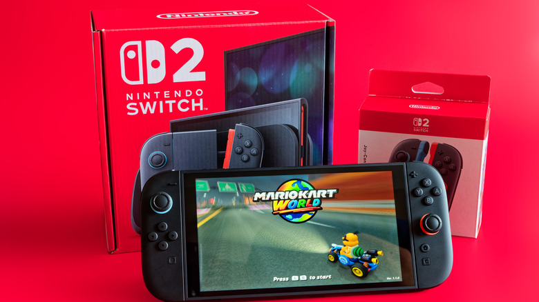 nintendo switch 2 in front of box, showing mario kart world start screen