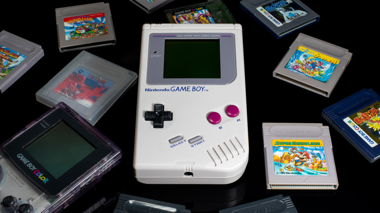 An original Nintendo Game Boy and Game Boy Color surrounded by cartridges including Tetris.