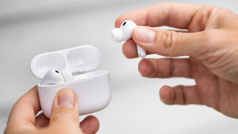 A closeup of someone holding AirPods Pro with case