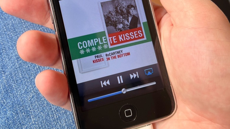 A person holding an iPod touch 3 playing music