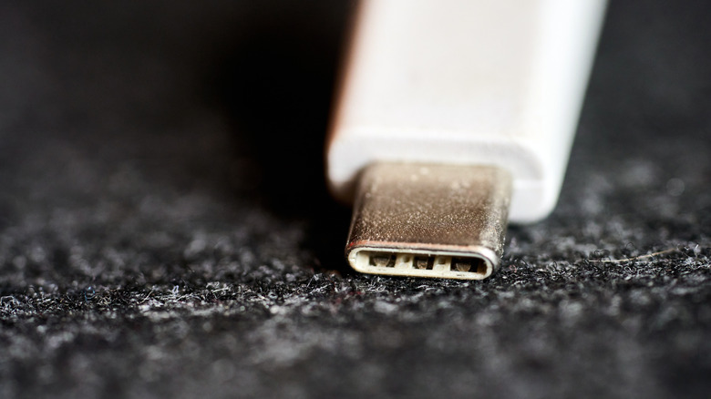 Close up of a USB-C connector on a dark surface.