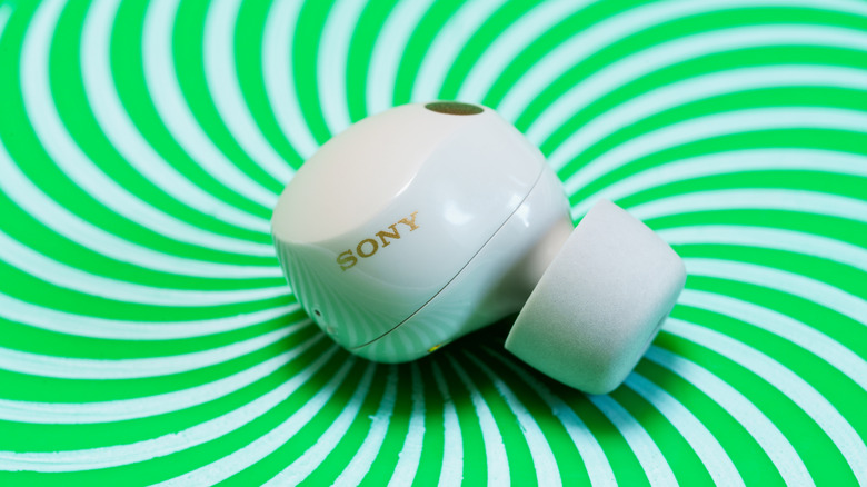A Sony WF-1000XM5 silver in-ear bud.
