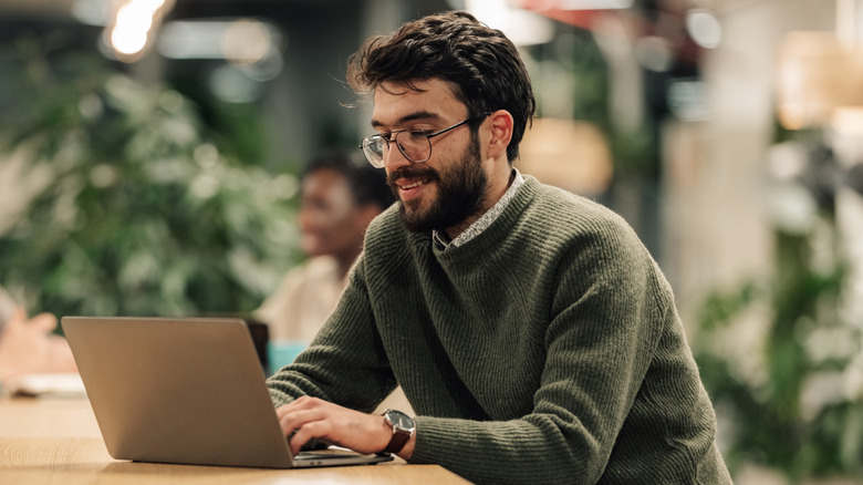 A man using a laptop in a public space