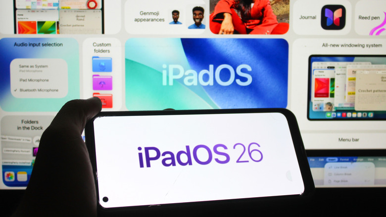 A person holding a smartphone in front of an iPadOS 26 backdrop. The same iPadOS 26 logo is on the phone screen.