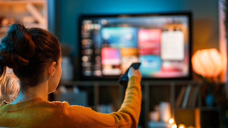 Woman holding a remote and watching television