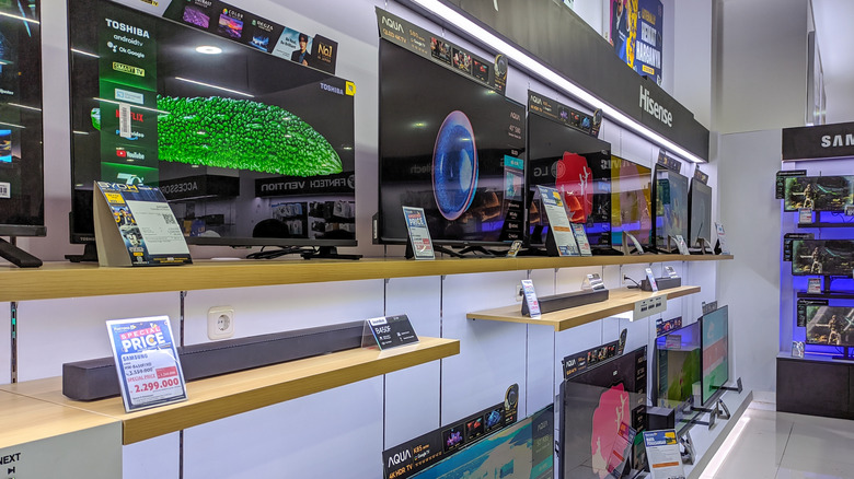 A home theater section at a retail outlet. Various TVs and soundbars are displayed.