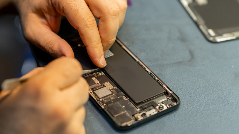 a person trying to repair a smartphone