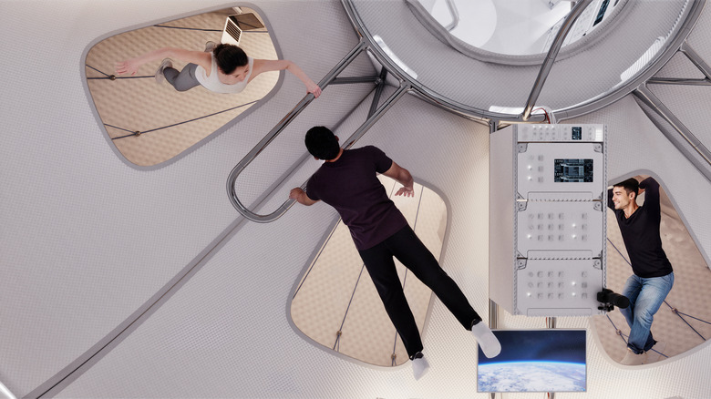 Three astronauts relax in zero gravity as they navigate the inside of the Thunderbird spacecraft.
