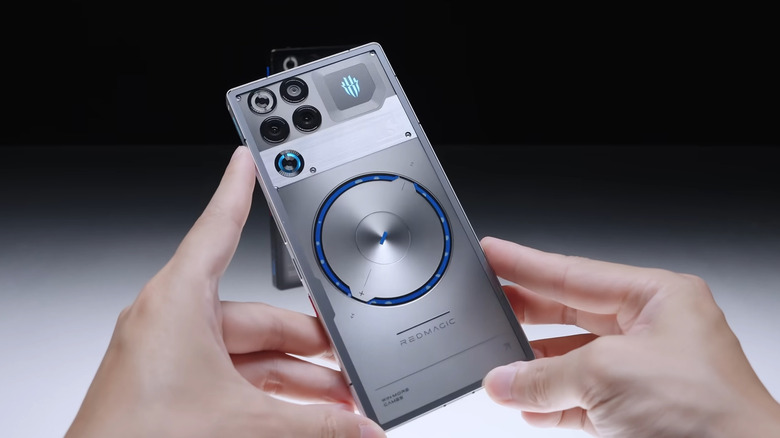A RedMagic phone held by a user in front of a black background
